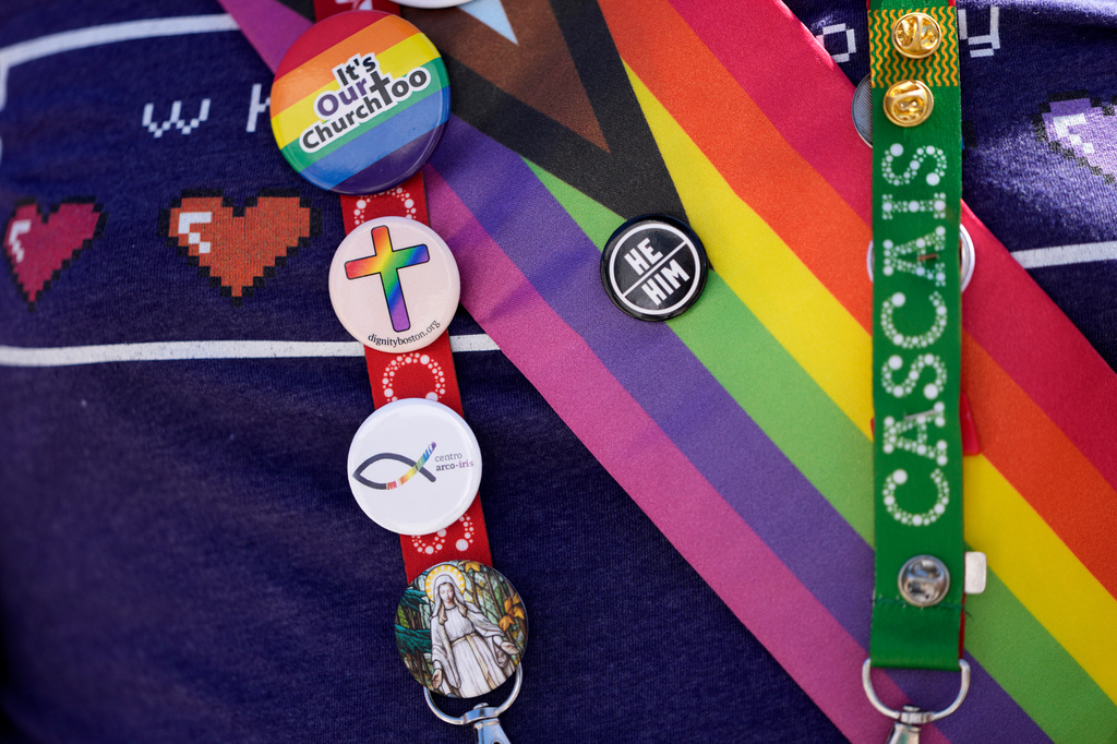 FILE - A representative of Dignity USA, a group of LGBTQ+ Catholics, wears pins on the lanyard of his pilgrim credential, outside the Sao Vicente de Paulo Parish Social Center after Pope Francis visited the center in the Serafina neighbourhood of Lisbon, Aug. 4, 2023. (AP Photo/Armando Franca, File)