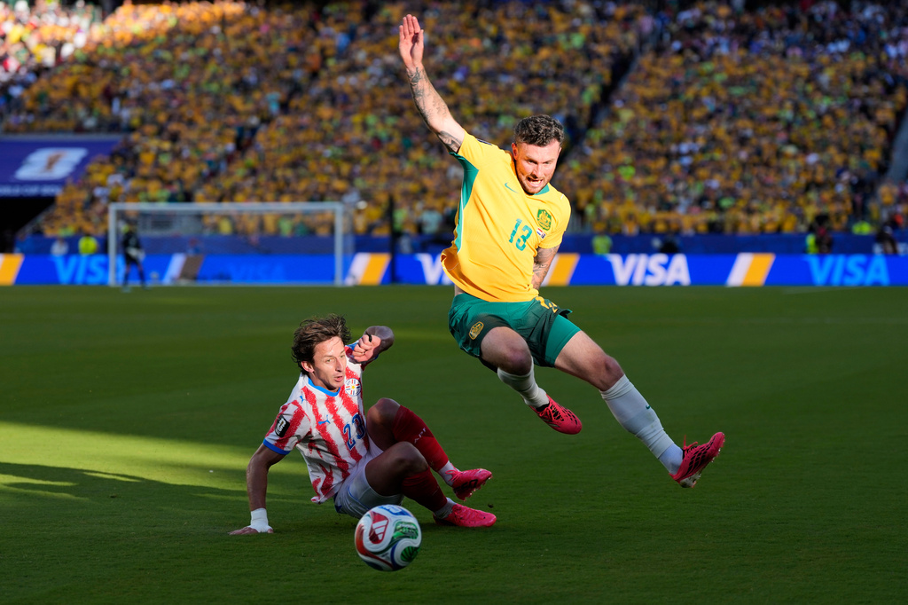 Australia's Aiden O'Neill (13) battles for the ball with Paraguay's Matias Galarza (23) during the World Cup Group D soccer match between Paraguay and Australia in Santa Clara, Calif., near San Francisco, Thursday, June 25, 2026. (AP Photo/Eugene Hoshiko)