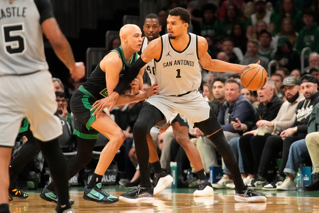 San Antonio Spurs forward Victor Wembanyama (1) is guarded by Boston Celtics guard Jordan Walsh (27) during the first half of an NBA basketball game Saturday, Jan. 10, 2026, in Boston. (AP Photo/Robert F. Bukaty)