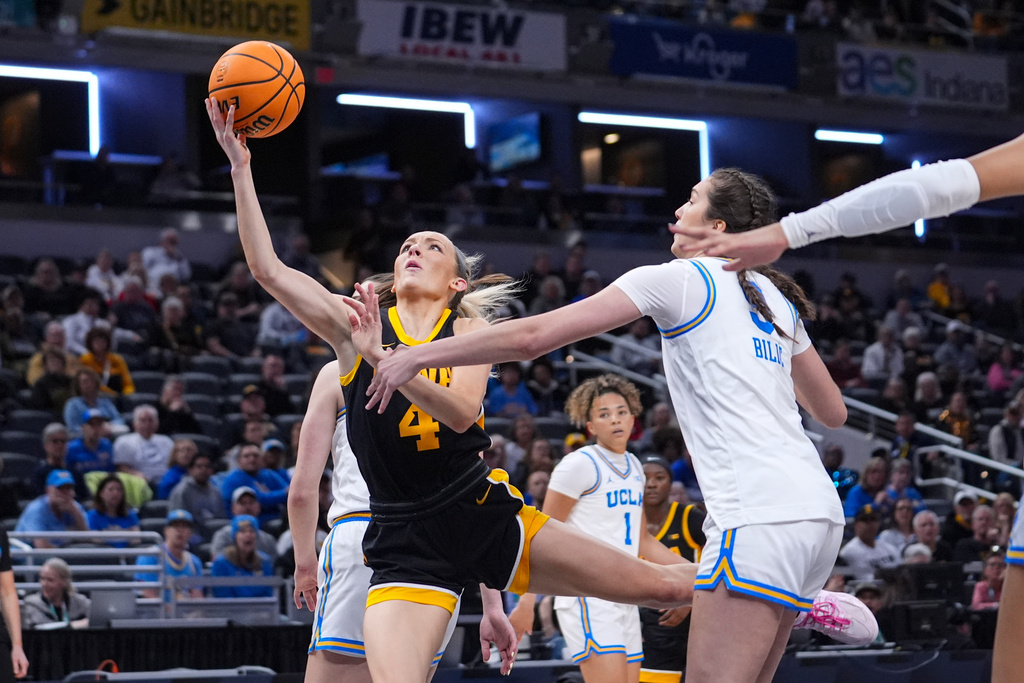 Iowa guard Kylie Feuerbach (4) shoots past UCLA guard Lena Bilic (9) in the first half of an NCAA college basketball game in the finals of the Big Ten Conference tournament, Sunday, March 8, 2026 in Indianapolis. (AP Photo/Michael Conroy)