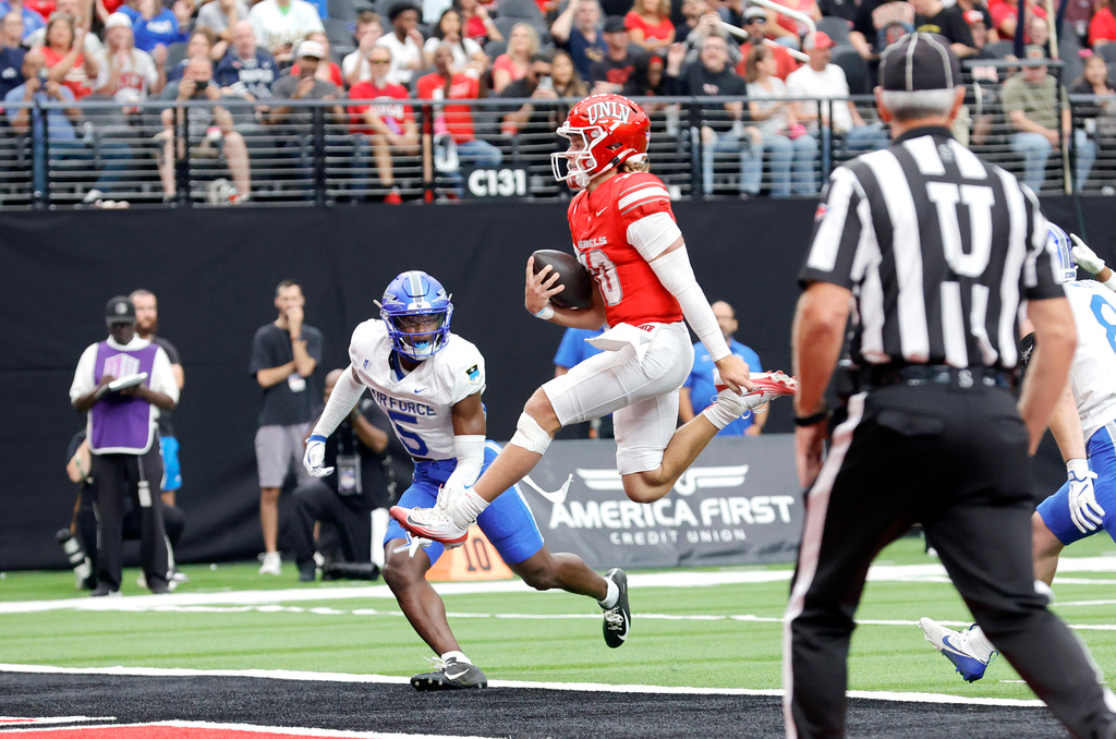 UNLV quarterback Anthony Colandrea (10) scores a touchdown in front of Air Force defensive back Roger Jones (5) during the first half of an NCAA college football game Saturday, Oct. 11, 2025, in Las Vegas. (Steve Marcus/Las Vegas Sun via AP)
