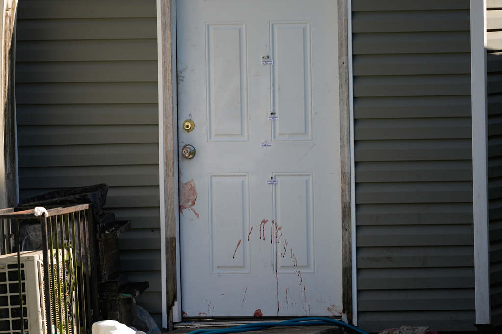 A door that appears to be stained with blood and evidence markers is closed outside the scene of a mass shooting, Sunday, April 19, 2026, in Shreveport, La. (AP Photo/Gerald Herbert)