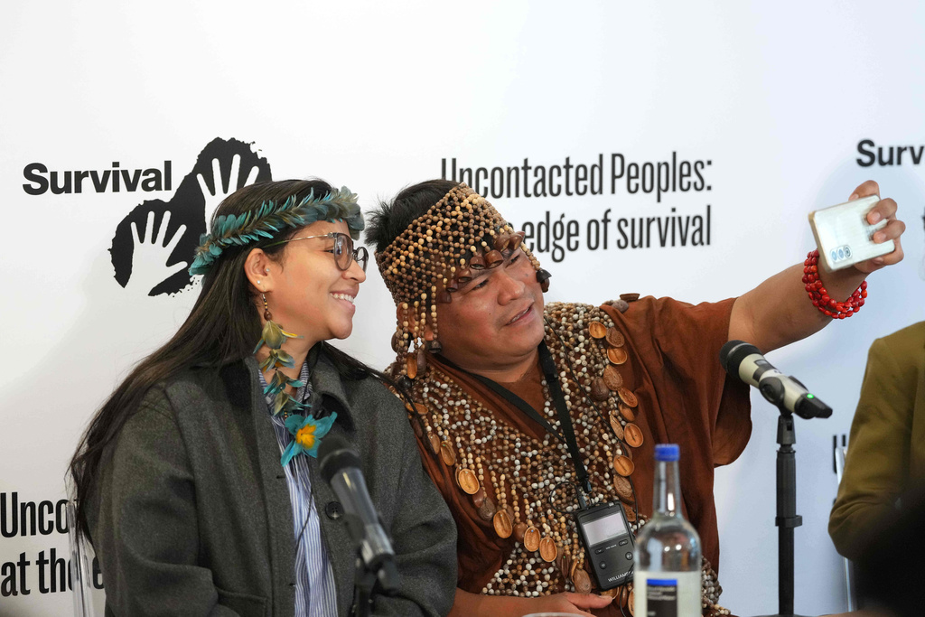 Maipatxi Apurina, left, and Herlin Odicio, right, take a photograph at the launch of Survival International's major new report on the world's uncontacted Indigenous peoples, in London, Monday, Oct. 27, 2025. (AP Photo/Kirsty Wigglesworth)