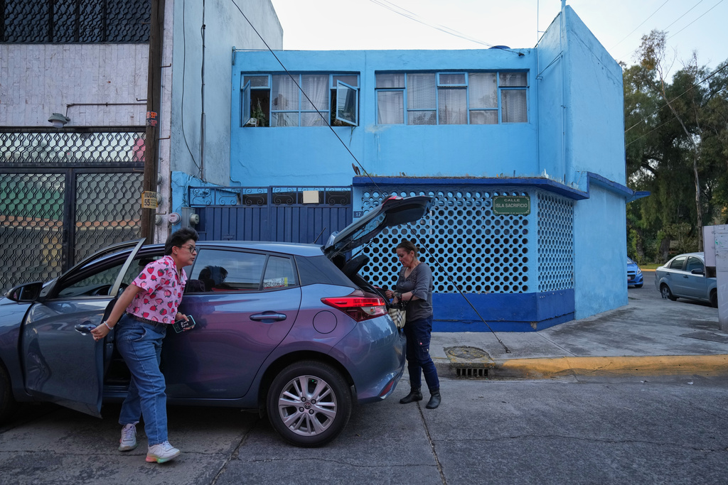 Diana Guzman, left, a driver with the feminist transportation collective AmorrAs, and passenger Ninfa Fuentes, right, arrive at Fuentes' home in the State of Mexico, Thursday, Nov. 6, 2025. (AP Photo/Claudia Rosel)