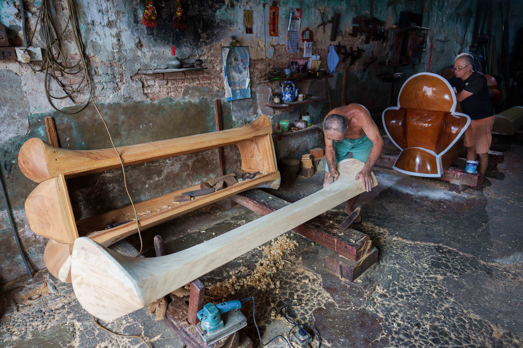 Traditional Chinese coffin maker Goh Khuay Par, left, carves a Mei Hua coffin as his brother Goh Khuay Hou paints another at their workshop in Muar, Johor state, Malaysia, Thursday, Sept. 3, 2026. (AP Photo/Vincent Thian)