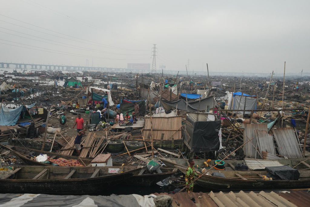 People stand on the ruins of their demolished stilts houses by authorities at Makoko slum in Lagos, Nigeria, Wednesday, Jan. 14, 2026. (AP Photo/Sunday Alamba)