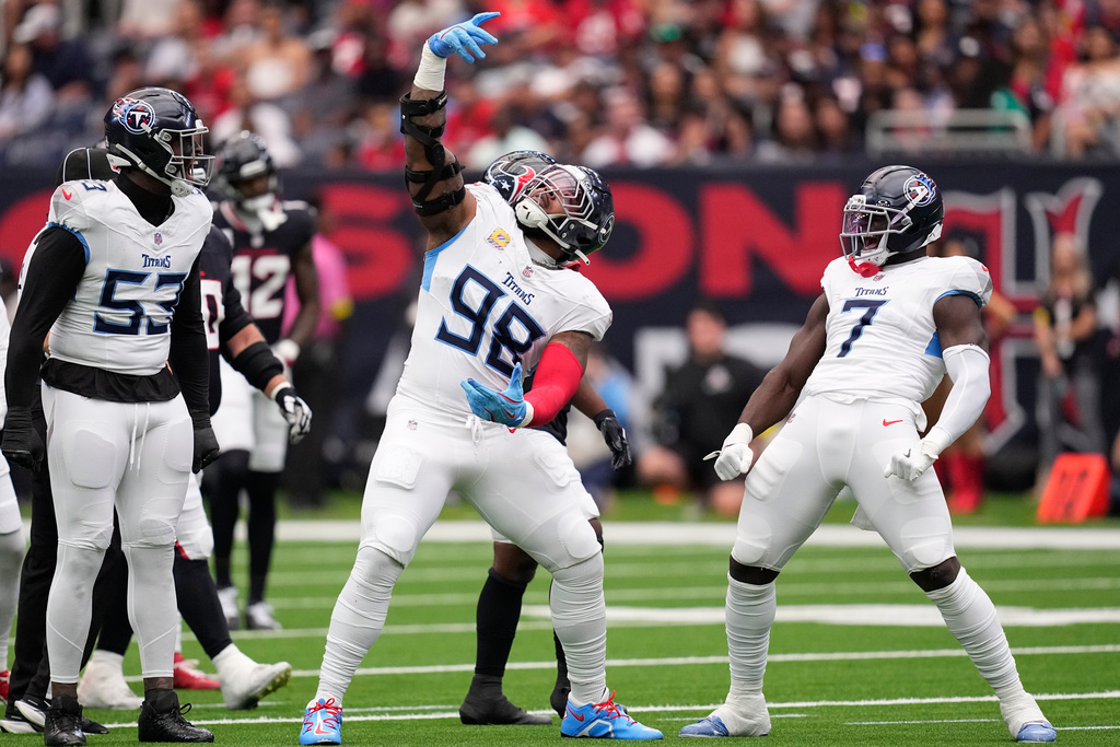 Tennessee Titans defensive tackle Jeffery Simmons (98) celebrates his sack with linebackers Jihad Ward (53) and Oluwafemi Oladejo (7) during the first half of an NFL football game against the Houston Texans, Sunday, Sept. 28, 2025, in Houston. (AP Photo/David J. Phillip)