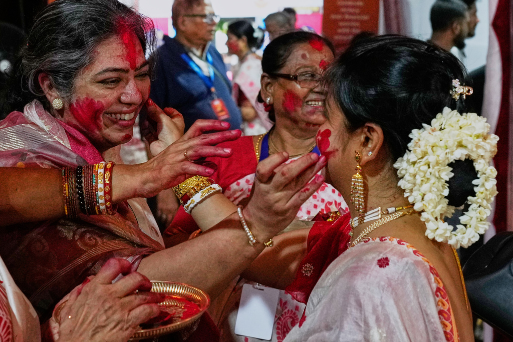 Hindu women smear vermillion on each other on the final day of the Durga Puja festival in Mumbai, India, Thursday, Oct. 2, 2025. (AP Photo/Rajanish Kakade)