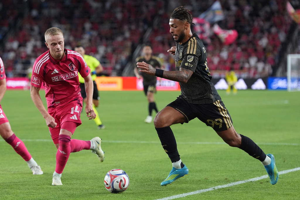 Los Angeles FC's Denis Bouanga (99) and St. Louis City's Tomas Totland (14) battle for the ball during the first half of an MLS soccer match Wednesday, May 13, 2026, in St. Louis. (AP Photo/Jeff Roberson)