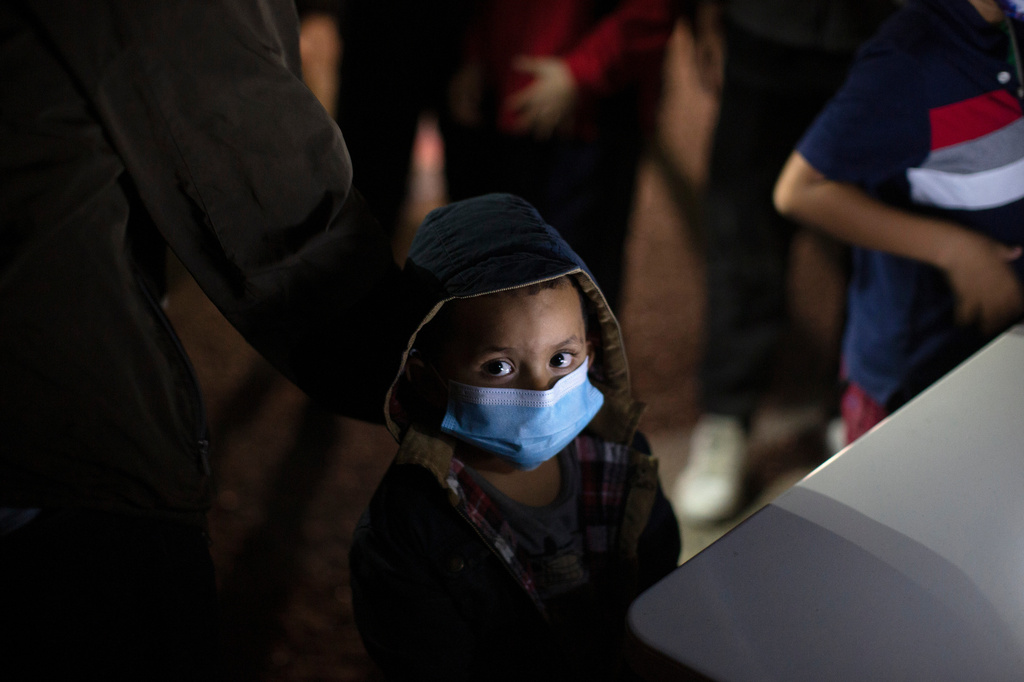 FILE - An unaccompanied minor looks up as he waits to answer questions from a U.S. Border Patrol agent at an intake site after he was smuggled on an inflatable raft across the Rio Grande River, March 24, 2021, in Roma, Texas. (AP Photo/Dario Lopez-Mills, File)