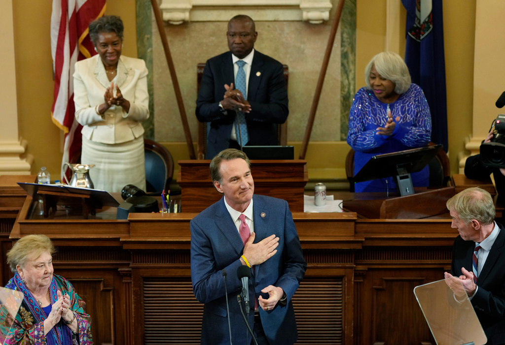 Virginia Gov. Glenn Youngkin acknowledges the applause as he delivers his State of the Commonwealth Address during the opening of the 2026 session of the General Assembly at the Capitol in Richmond, Va., Wednesday, Jan. 14, 2026. Lt. Gov. Winsome Earl-Sears, top left, House Speaker, Don Scott, D-Portsmouth, top center, and Senate President Pro ten, Louise Lucas, D-Portsmouth, join in the welcome. (AP Photo/Steve Helber)