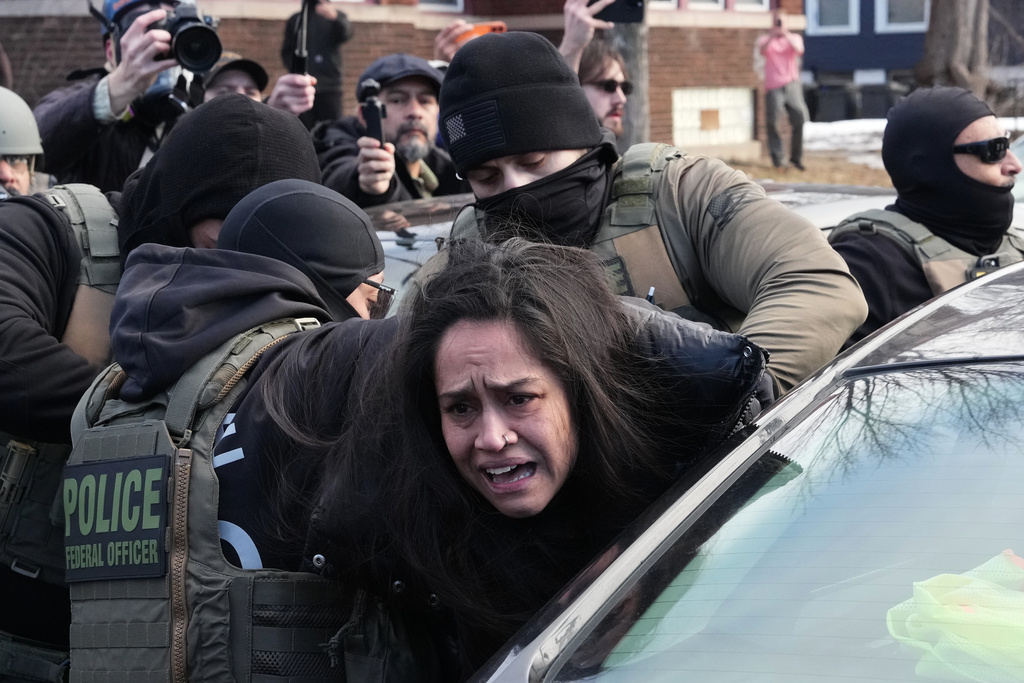 A protester is detained by Federal agents near the scene where Renee Good was fatally shot by an ICE officer last week, Tuesday, Jan. 13, 2026, in Minneapolis.(AP Photo/Adam Gray)