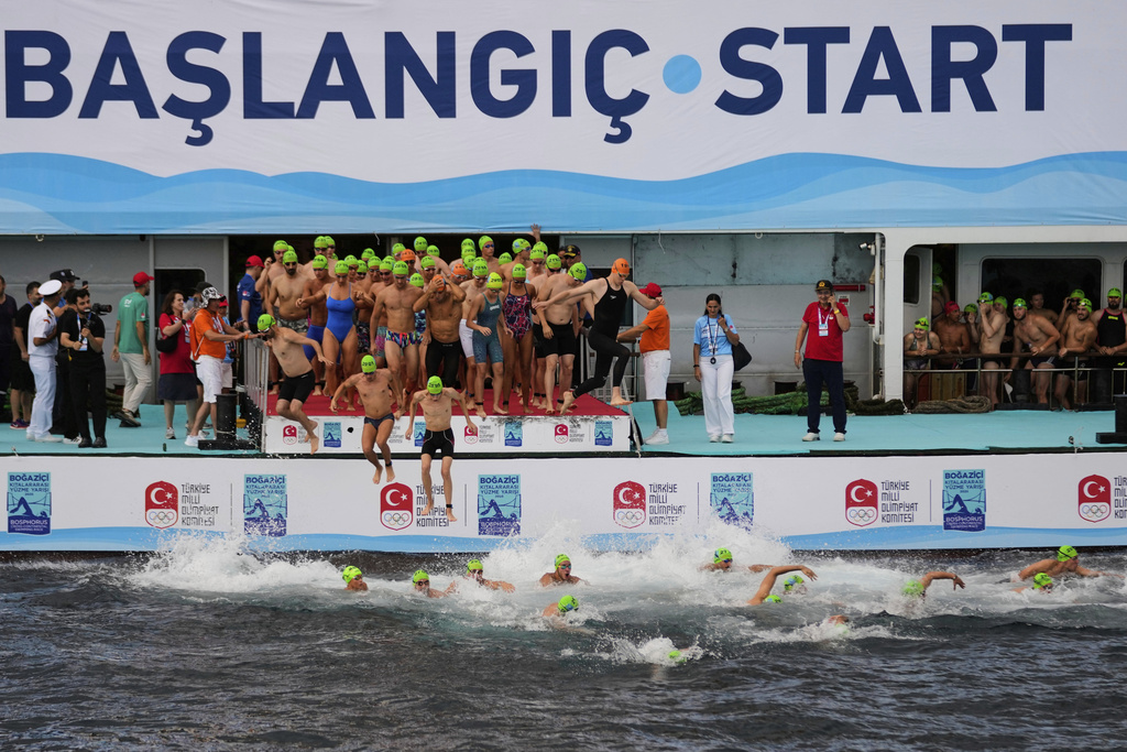 Competitors jump into the water at the start of a 6.5km swimming race across the Bosporus Strait, from the Asian side to the European side, in Istanbul, Turkey, Sunday, Aug. 24, 2025. (AP Photo/Khalil Hamra)