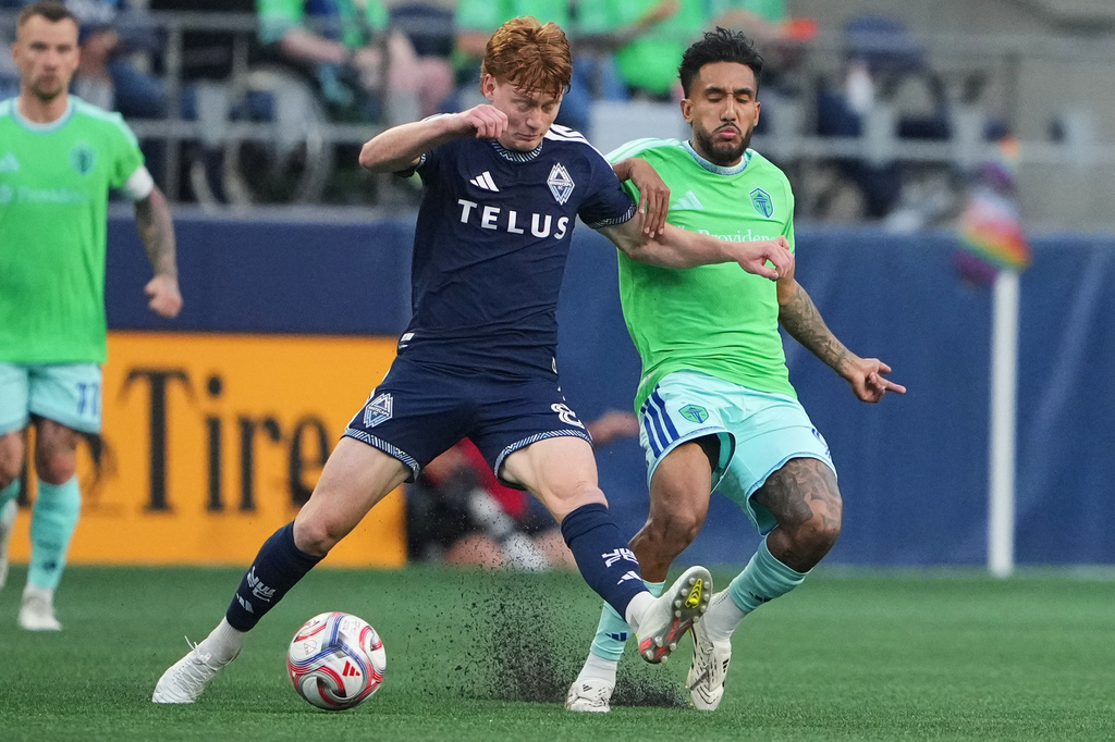 Vancouver Whitecaps midfielder Oliver Larraz, left, goes for the ball against Seattle Sounders forward Jesús Ferreira, right, during the first half of an MLS soccer match, Sunday, Aug. 16, 2026, in Seattle. (AP Photo/Lindsey Wasson)