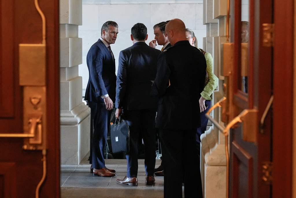 U.S. Secretary of Defense Pete Hegseth, left, talks to staff as he leaves the U.S. Capitol building on day 36th of the government shutdown, Wednesday, Nov. 5, 2025, in Washington. (AP Photo/Mariam Zuhaib)