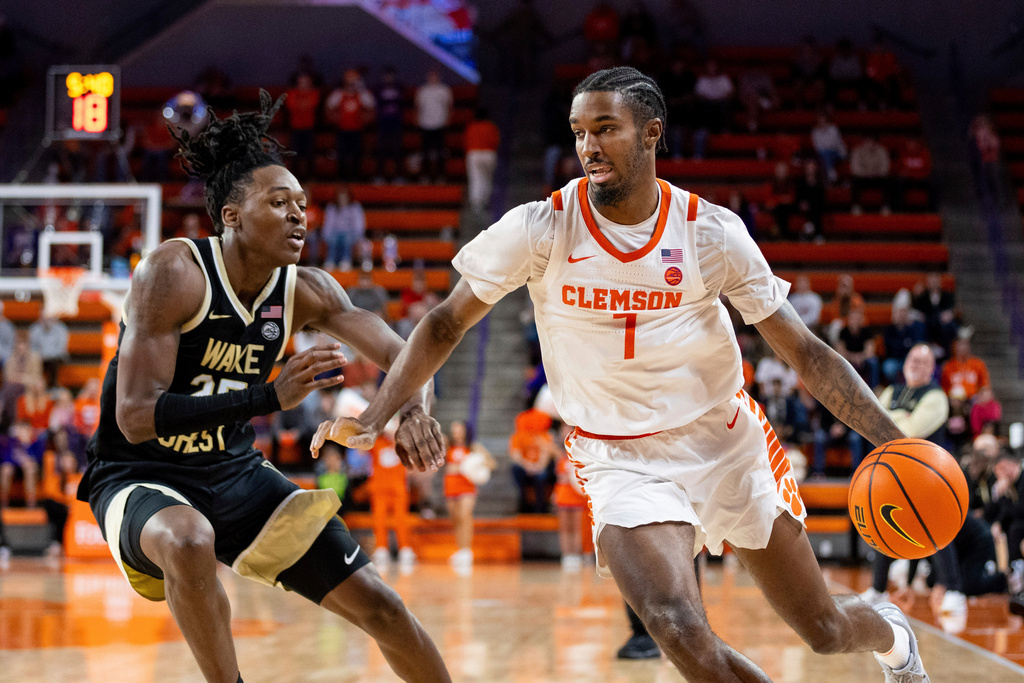 FILE - Clemson Tigers forward Chauncey Wiggins (7) drives around Wake Forest Demon Deacons forward Tre'Von Spillers (25) during the second half of an NCAA basketball game Dec. 21, 2024, in Clemson, N.C. (AP Photo/Scott Kinser, File)