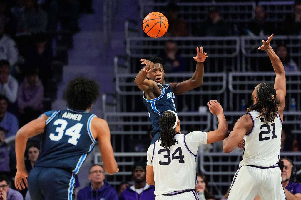 BYU forward AJ Dybantsa (3) passes the ball over Kansas State guard Nate Johnson (34) and forward Khamari McGriff (21) during the second half of an NCAA college basketball game Saturday, Jan. 3, 2026, in Manhattan, Kan. (AP Photo/Charlie Riedel)