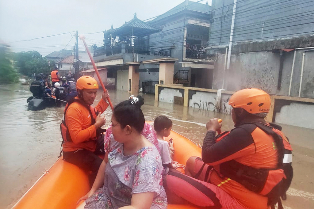 In this photo released by Indonesia's National Search and Rescue Agency (BASARNAS), rescuers on a rubber boat evacuate residents from their flooded home in Denpasar, Bali, Indonesia Wednesday, Sept. 10, 2025. (BASARNAS via AP)
