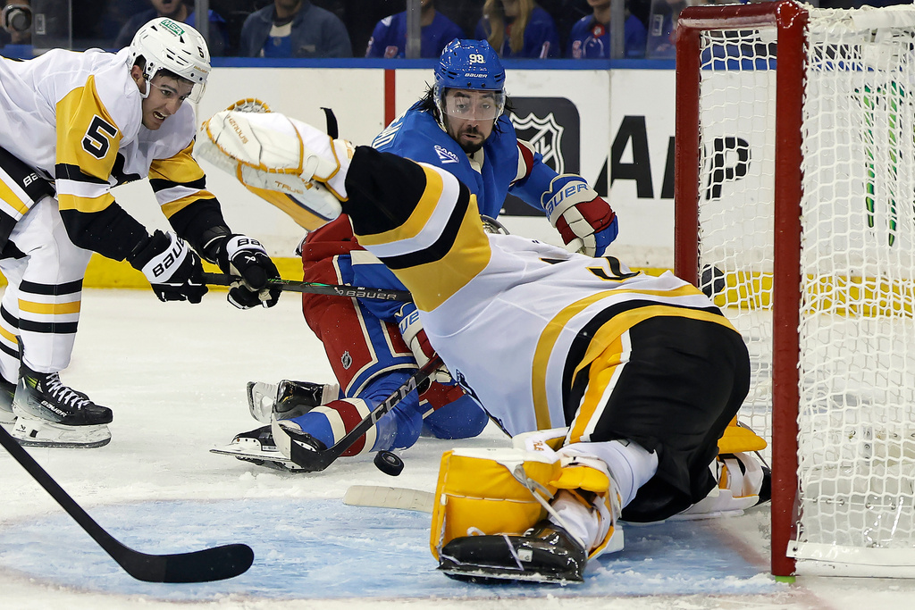 New York Rangers center Mika Zibanejad (93) watches Pittsburgh Penguins goaltender Arturs Silovs (37) make a save on his shot in front of defenseman Ryan Shea (5) in the second period of an NHL hockey game Tuesday, Oct. 7, 2025, in New York. (AP Photo/Adam Hunger)
