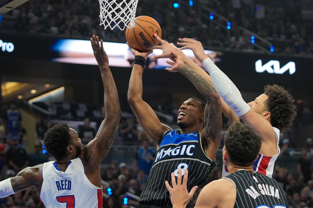Orlando Magic forward Jamal Cain, center, struggles to get off a shot between Detroit Pistons forward Paul Reed, left, and guard Cade Cunningham during the second half in Game 6 of a first-round NBA basketball playoffs series, Friday, May 1, 2026, in Orlando, Fla. (AP Photo/John Raoux)