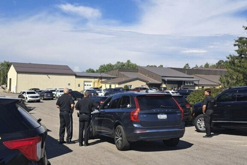 In this photo provided by Rural & Migrant Ministry, law enforcement officers gather outside during a raid on a snack bar manufacturer Friday, Sept. 5, 2025, in Cato, N.Y. (Ana Mendez-Vasquez/Rural & Migrant Ministry via AP)