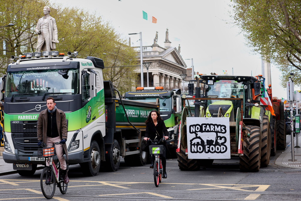 Cyclists ride past tractors blocking O'Connell Street on the fifth day of the National Fuel Protest, in Dublin, Ireland, Saturday, April 11, 2026. (AP Photo/Peter Morrison)