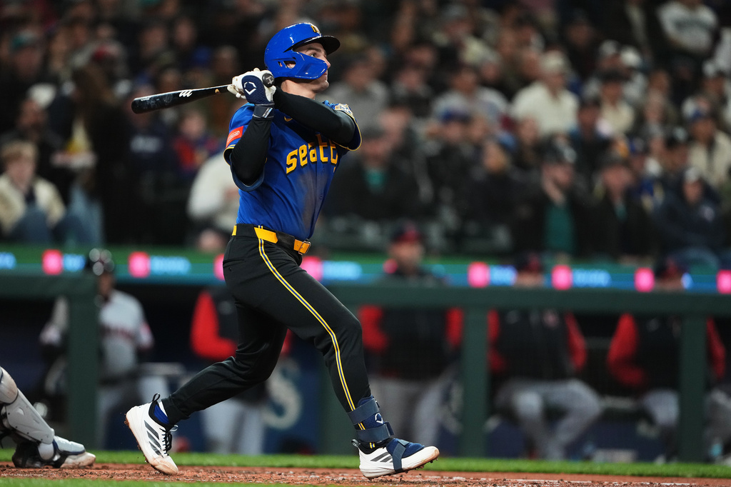 Seattle Mariners' Cole Young follows through on a three-run home run against the Cleveland Guardians during the fourth inning of a baseball game, Friday, March 27, 2026, in Seattle. (AP Photo/Lindsey Wasson)