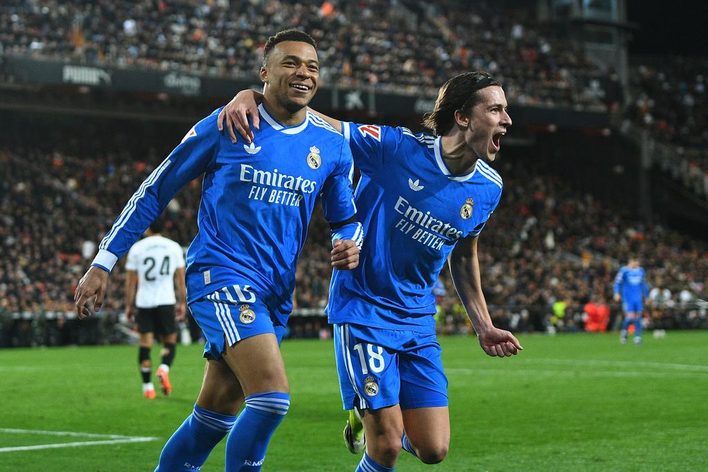 Real Madrid's Kylian Mbappe, left, celebrates with Alvaro Carreras after scoring his side's second goal during the Spanish La Liga soccer match between Valencia and Real Madrid in Valencia, Spain, Sunday, Feb. 8, 2026. (AP Photo/Francisco Macia)