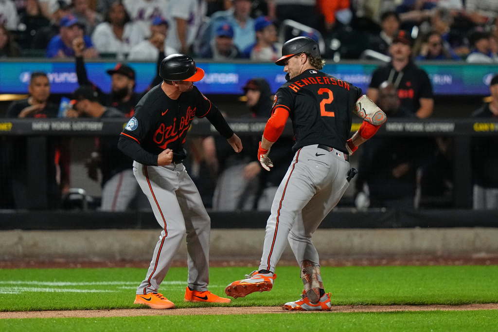 Baltimore Orioles third base coach Buck Britton, left, celebrates with Gunnar Henderson, right, as Henderson runs the bases after hitting a home run during the eighth inning of a baseball game against the New York Mets Monday, Sept. 14, 2026, in New York. (AP Photo/Frank Franklin II)