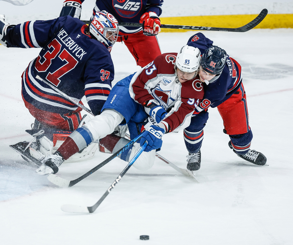 Winnipeg Jets' Cole Perfetti (91) vies for the puck with Colorado Avalanche's Zakhar Bardakov (93) during second period of an NHL game in Winnipeg, Manitoba, Saturday, March 14, 2026. (John Woods/The Canadian Press via AP)