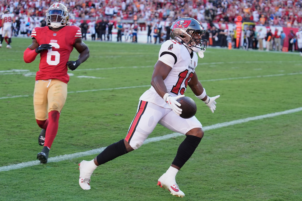 Tampa Bay Buccaneers wide receiver Kameron Johnson, right, celebrates after scoring past San Francisco 49ers safety Malik Mustapha (6) during the first half of an NFL football game in Tampa, Fla., Sunday, Oct. 12, 2025. (AP Photo/Chris O'Meara)