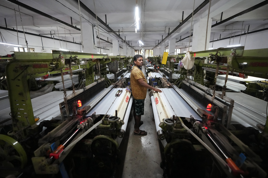 Migrant worker Sibaram Pradhan works at a power loom factory that produces polyester cloth in Surat, India, Thursday, May 28, 2026. (AP Photo/Ajit Solanki)