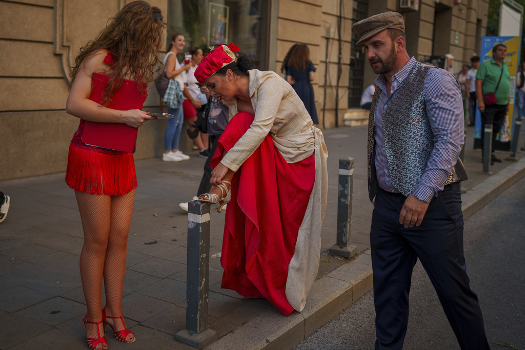 An artist of the Bucharest Metropolitan Circus adjusts her shoe during an event marking the day when the Romanian capital was first mentioned in historical records, 566 years ago, in Bucharest, Romania, Saturday, Sept. 20, 2025. (AP Photo/Vadim Ghirda)
