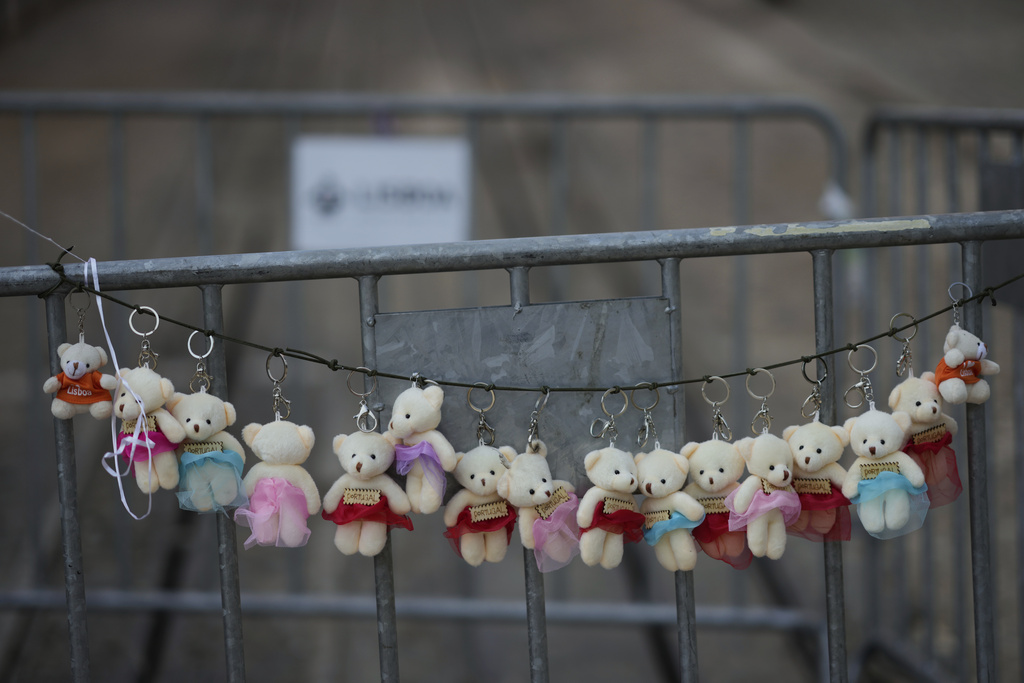 Sixteen small plush toys are hung on the barriers blocking access to the downtown stop of the Gloria funicular, a tourist streetcar that derailed and crashed, in Lisbon, Saturday, Sept. 6, 2025. (AP Photo/Armando Franca)