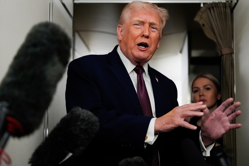 President Donald Trump speaks to reporters while in flight on Air Force One to Joint Base Andrews, Md., Sunday, Jan. 11, 2026. (AP Photo/Julia Demaree Nikhinson)