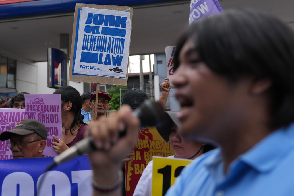 FILE - Protesters hold slogans during a rally against the recent big oil price hike on Tuesday, March 10, 2026, outside a gasoline station in Quezon city, Philippines. (AP Photo/Aaron Favila, File)