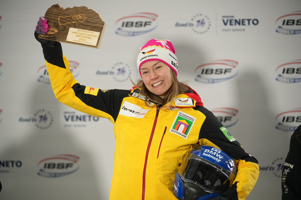First place winner Laura Nolte of Germany reacts on the podium after a women's monobob World Cup race and Olympic test event in Cortina d'Ampezzo, Italy, Saturday, Nov. 22, 2025. (AP Photo/Andrew Medichini)