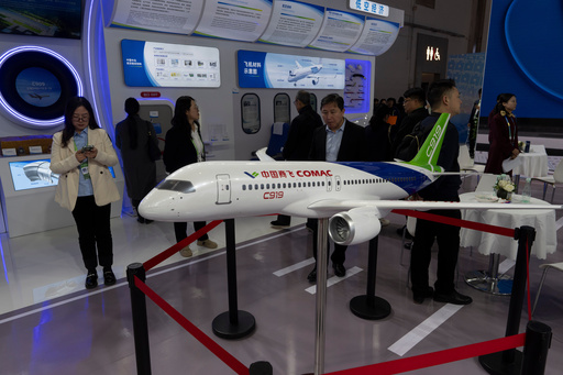 FILE - Attendees pass by a model of the Chinese-made C919 passenger jet at the Sinochem booth during the China International Supply Chain Expo in Beijing, Nov. 27, 2024. (AP Photo/Ng Han Guan, File) FILE - Attendees pass by a model of the Chinese-made C919 passenger jet at the Sinochem booth during the China International Supply Chain Expo in Beijing, Nov. 27, 2024. (AP Photo/Ng Han Guan, File)