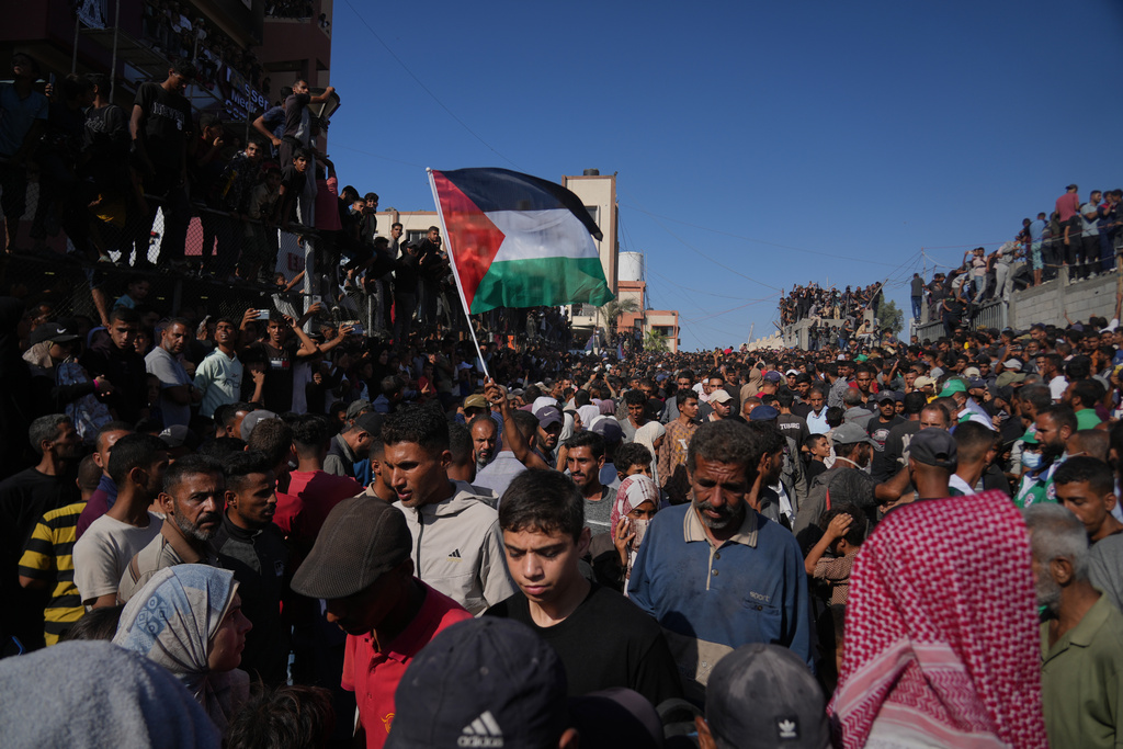 People gather to greet freed Palestinian prisoners as they arrive in the Gaza Strip after their release from Israeli jails under a ceasefire agreement between Hamas and Israel, outside Nasser Hospital in Khan Younis, southern Gaza Strip, Monday, Oct. 13, 2025. (AP Photo/Abdel Kareem Hana)