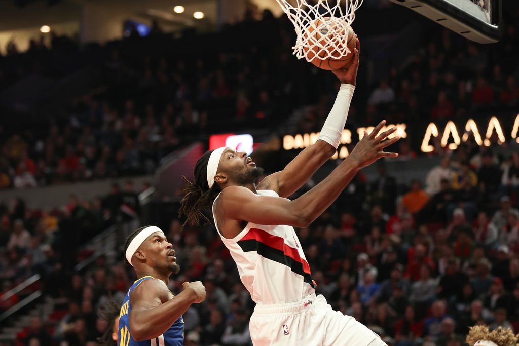 Portland Trail Blazers forward Jerami Grant (9) drives to the basket as Golden State Warriors forward Jimmy Butler III (10) defends during the first half of an NBA basketball game Friday, Oct. 24, 2025, in Portland, Ore. (AP Photo/Amanda Loman)