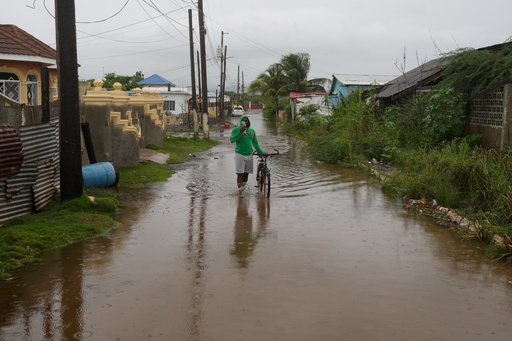 A man wades through a flooded street ahead of the forecasted arrival of Hurricane Melissa in Old Harbour, Jamaica, Monday, Oct. 27, 2025. (AP Photo/Matias Delacroix) A man wades through a flooded street ahead of the forecasted arrival of Hurricane Melissa in Old Harbour, Jamaica, Monday, Oct. 27, 2025. (AP Photo/Matias Delacroix)