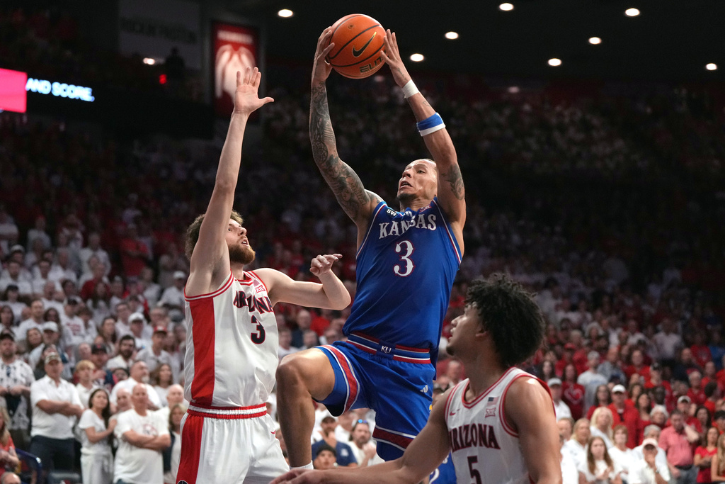 Kansas guard Tre White drives against Arizona guard Anthony Dell'orso (3) and guard Brayden Burries during the first half of an NCAA college basketball game Saturday, Feb. 28, 2026, in Tucson, Ariz. (AP Photo/Rick Scuteri)