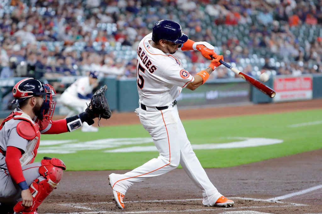 Houston Astros' Isaac Paredes, right, connects for an RBI double in front of Boston Red Sox catcher Connor Wong, left, during the first inning of a baseball game Wednesday, April 1, 2026, in Houston. (AP Photo/Michael Wyke)