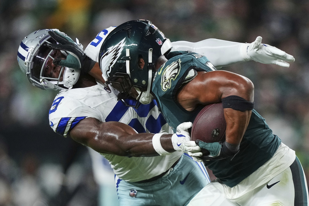Philadelphia Eagles running back Saquon Barkley, right, fights off a tackle attempt by Dallas Cowboys linebacker Kenneth Murray Jr. (59) in the second half of an NFL football game Thursday, Sept. 4, 2025, in Philadelphia. (AP Photo/Matt Slocum)