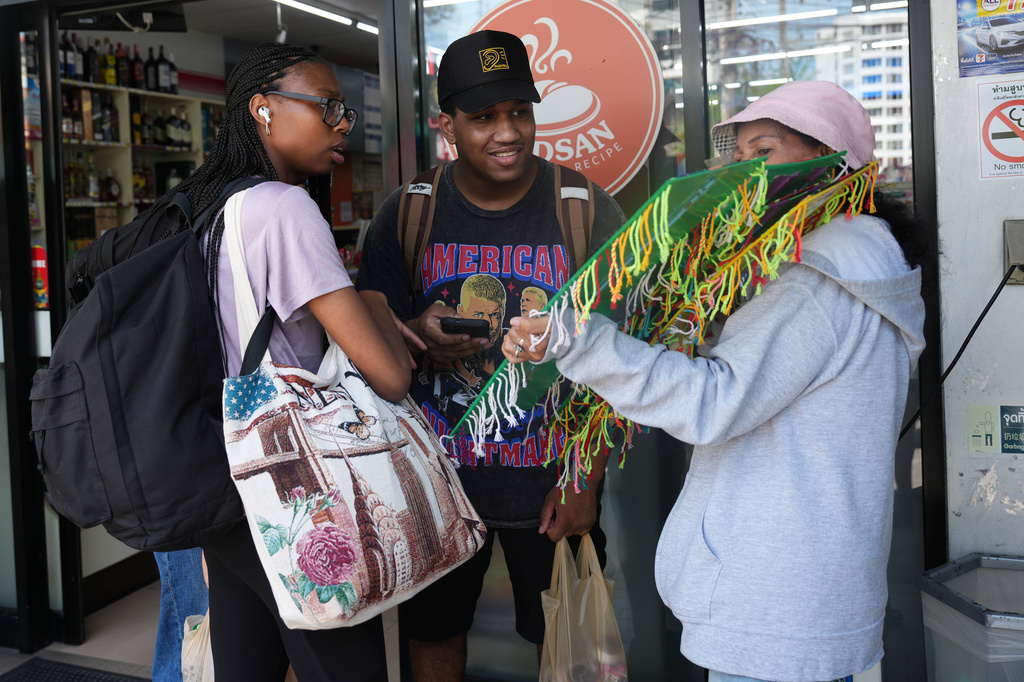 Crew members of the USS Abraham Lincoln talk to a souvenir vendor in Pattaya, Thailand, Thursday, Sept. 3, 2026. (AP Photo/Sakchai Lalit)