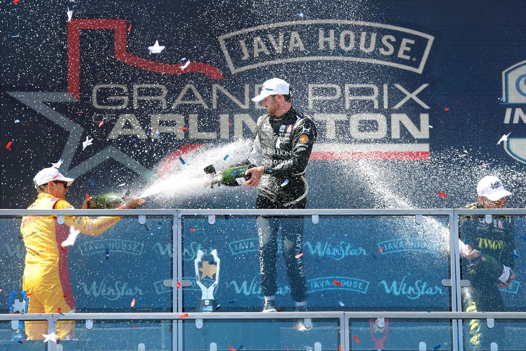 Grand Prix of Arlington winning driver Kyle Kirkwood of Andretti Global, center, is doused with champagne by second place finisher Alex Palou, left, and third place finisher Will Power following at the Grand Prix of Arlington auto race, Sunday, March 15, 2026, in Arlington, Texas. (Tom Fox/The Dallas Morning News via AP)