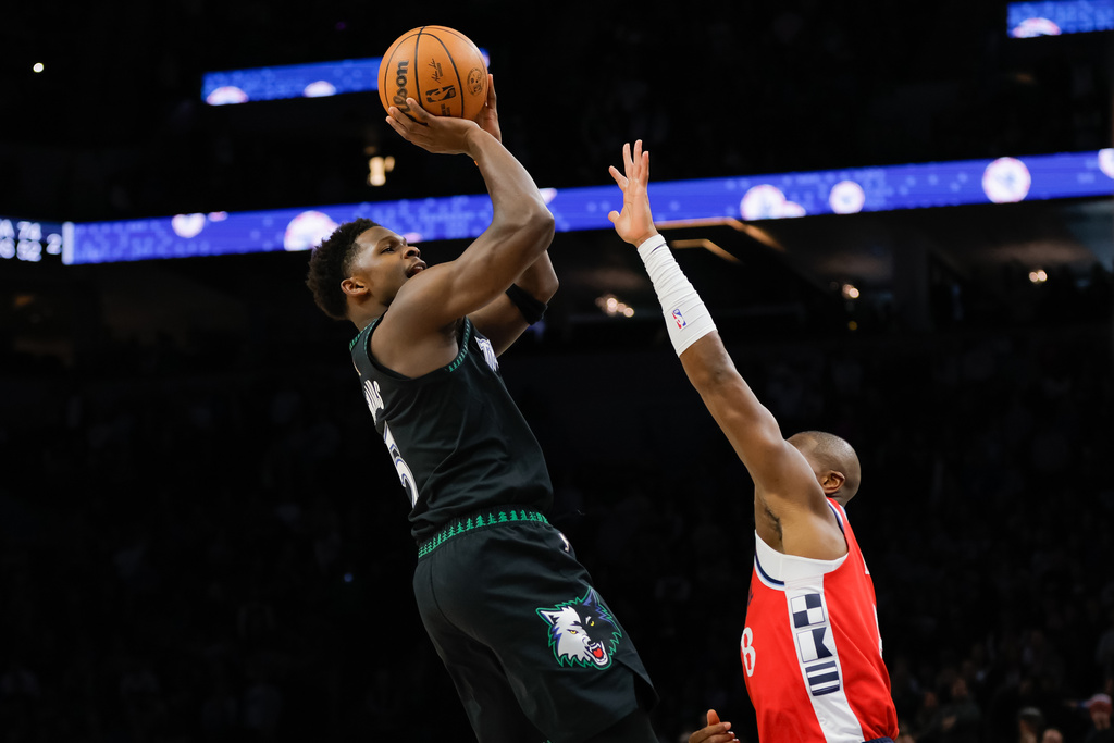 Minnesota Timberwolves guard Anthony Edwards, left, goes up to shoot over Los Angeles Clippers guard Kris Dunn, right, during the first half of an NBA basketball game, Sunday, Feb. 8, 2026, in Minneapolis. (AP Photo/Bailey Hillesheim)