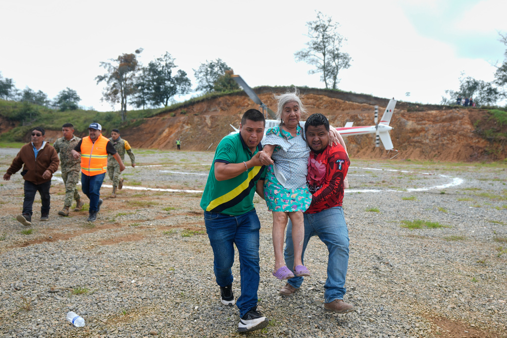 Volunteers help a woman deplane in Bella Vista, Hidalgo state, Mexico, Tuesday, Oct. 14, 2025, after she was evacuated from Chapula due to deadly landslides and flooding in the area triggered by the convergence of two tropical storms. (AP Photo/Fernando Llano)