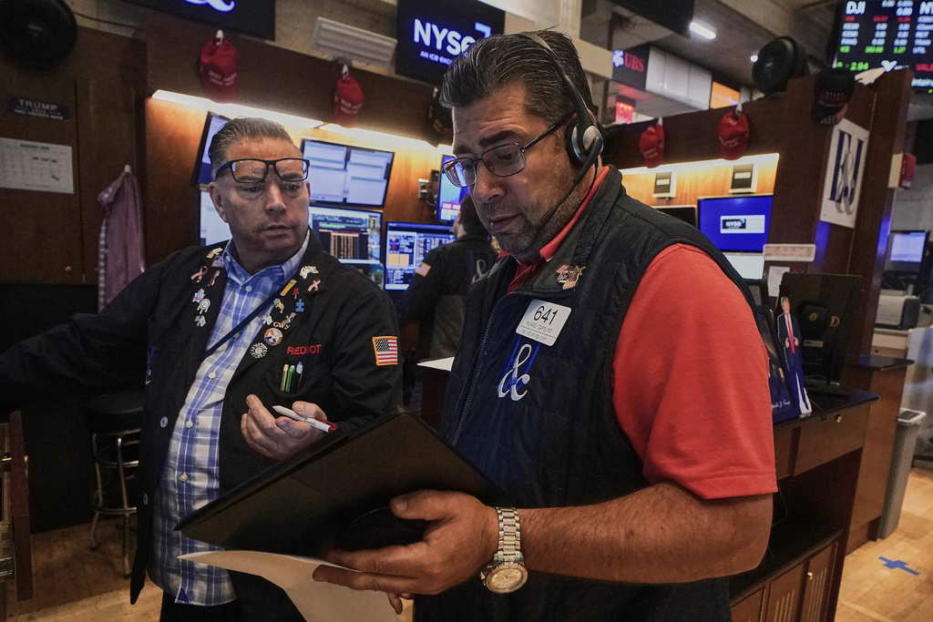 Traders Jonathan Mueller, left, and Michael Capolino work on the floor of the New York Stock Exchange, Friday, Aug. 15, 2025. (AP Photo/Richard Drew)