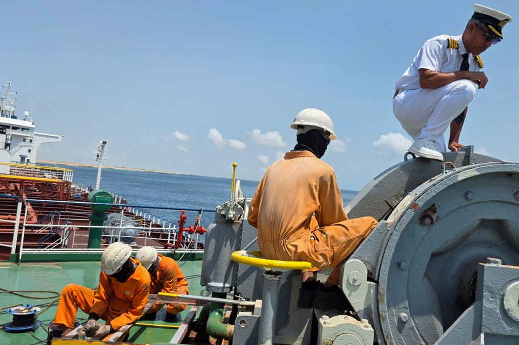 In this picture courtesy of Captain Rahman Al-Jubouri, right, he supervises sailors on the deck of the Sea Moon oil tanker on the waters the Gulf of Oman, Wednesday, April 15, 2026. (Photo courtesy of Capt. Rahman Al-Jubouri via AP)